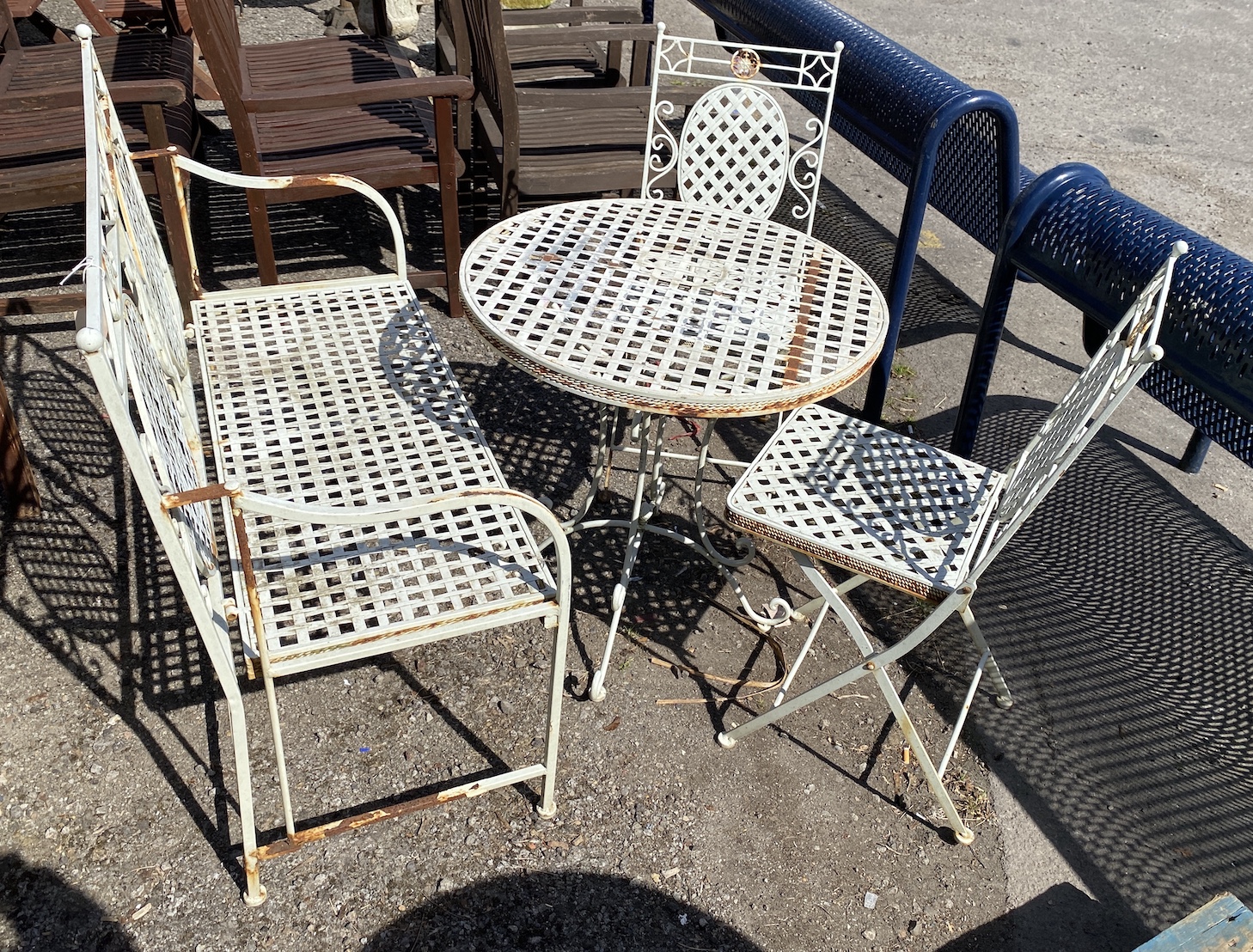 A metal folding garden bench, width 103cm, height 96cm, a pair of chairs and a circular table